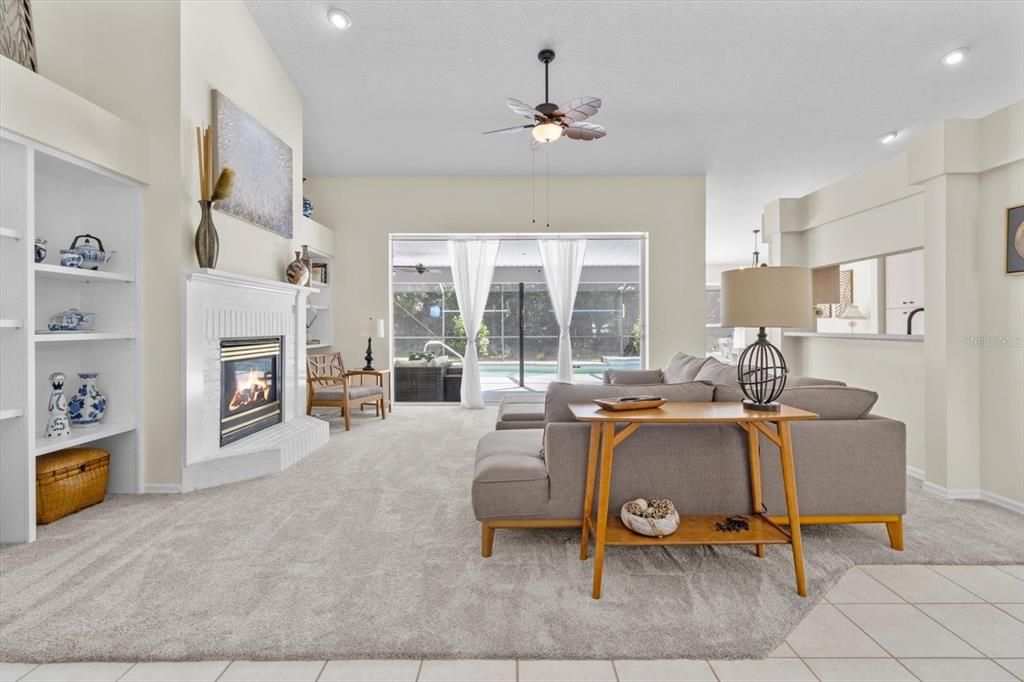 Living Room w/ NEW Carpeting, Vaulted Ceiling, Fireplace w/ Brick Hearth, Built-Ins, Plant Shelves & 3 Panel Pocket (Hideaway) Slider