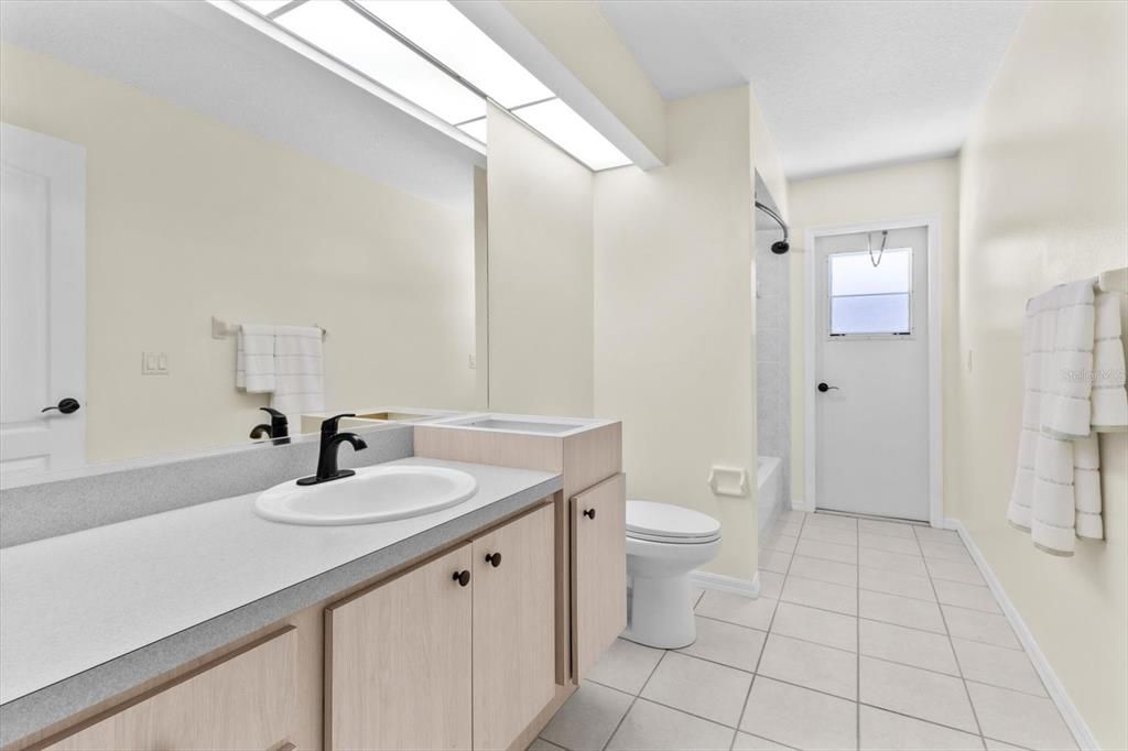 Bathroom 2 w/ NEW High Efficiency Center Flush Toilet, NEW Plumbing Fixtures & Door to the Lanai