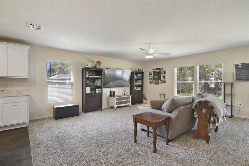 The kitchen overlooks open living and dining areas with sliding glass door access to the patio and backyard.