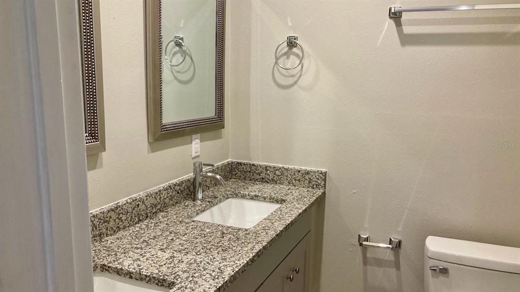 Unit A bathroom with double vanity and granite countertops