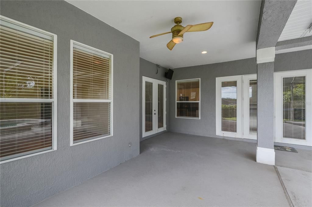 View of primary bedroom windows to left; French doors to left for living room; Single window for kitchen; French doors to right for family room