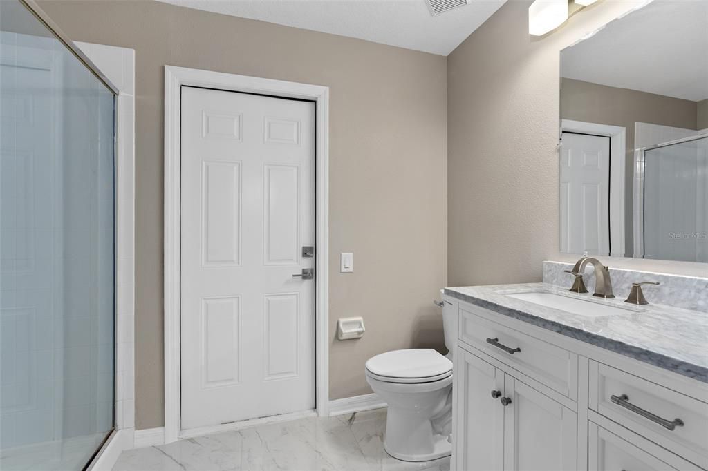 BATHROOM 3 REMODELED AS WELL WITH 24 INCH PORCELAIN TILE, CUSTOM VANITY WITH STONE COUNTETOP, NEW LIGHTING AND FAUCETS.