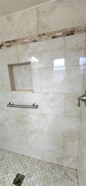 ensuite bath in primary with beautifully remodeled shower stall