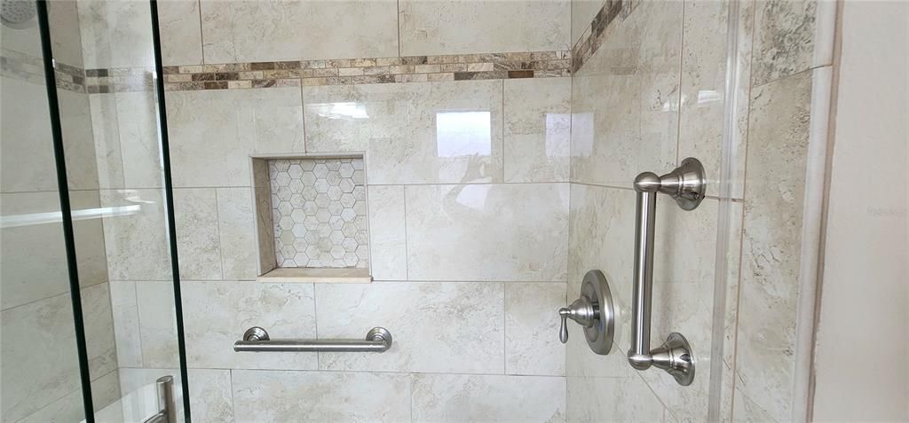 ensuite bath in primary with beautifully remodeled shower stall