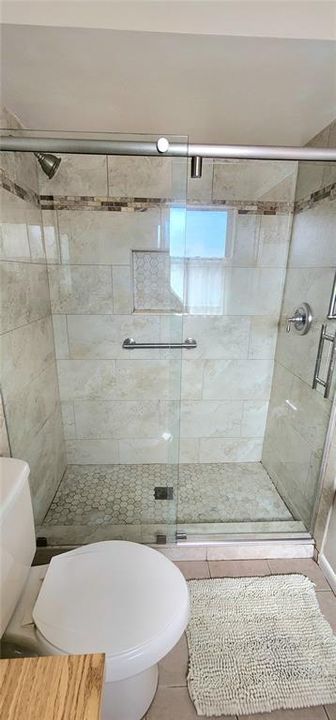 Ensuite bath in primary with beautifully remodeled shower stall