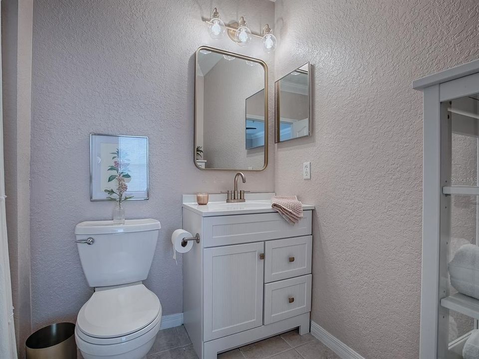 Primary Bathroom featuring a new Vanity with Sink, Toilet, Mirror and Lighting Fixture.