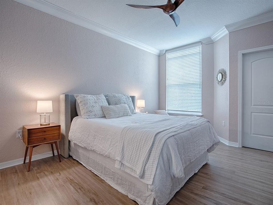 Primary Bedroom featuring new Luxury Vinyl Plank Flooring, New Ceiling Fan, New Paint, Crown Molding, Walki-in Closet and an en-suite Bathroom.