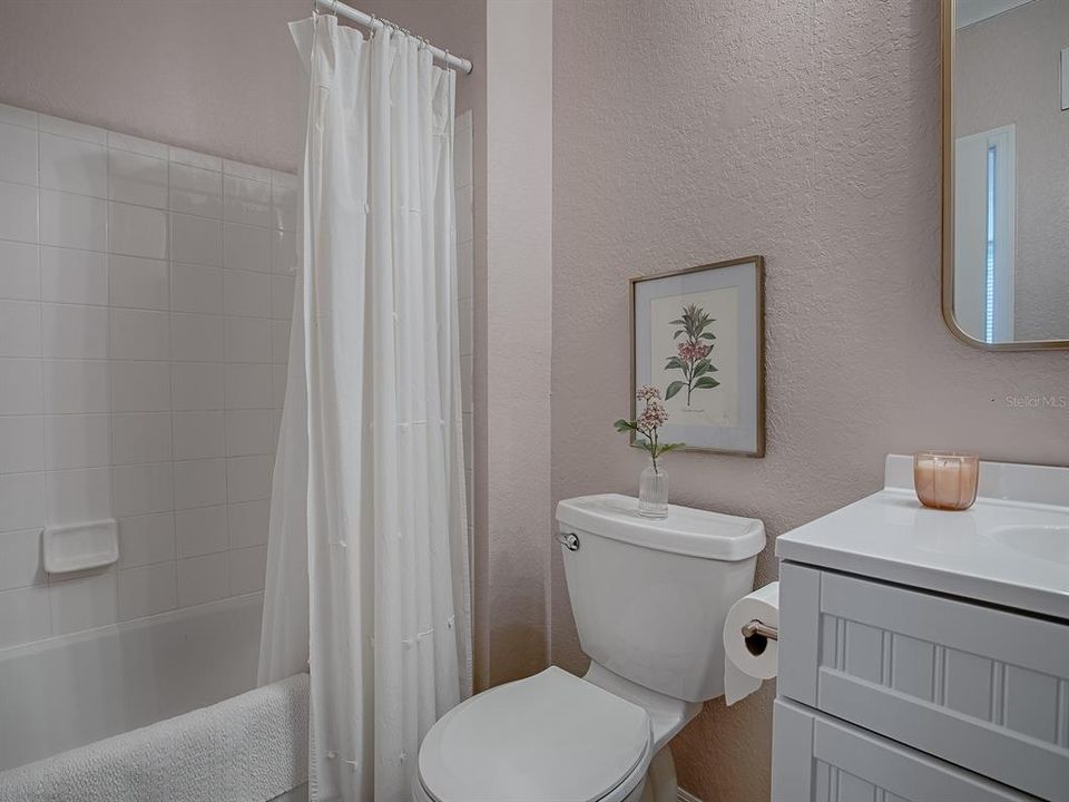 Primary Bathroom featuring a new Vanity with Sink, Toilet, Mirror and Lighting Fixture.