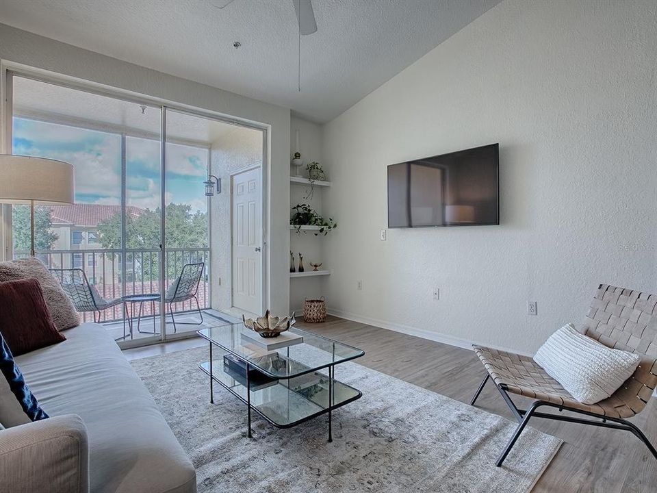 Living Room with Sliding Glass Doors leading to Screened-in Lanai and Storage Closet