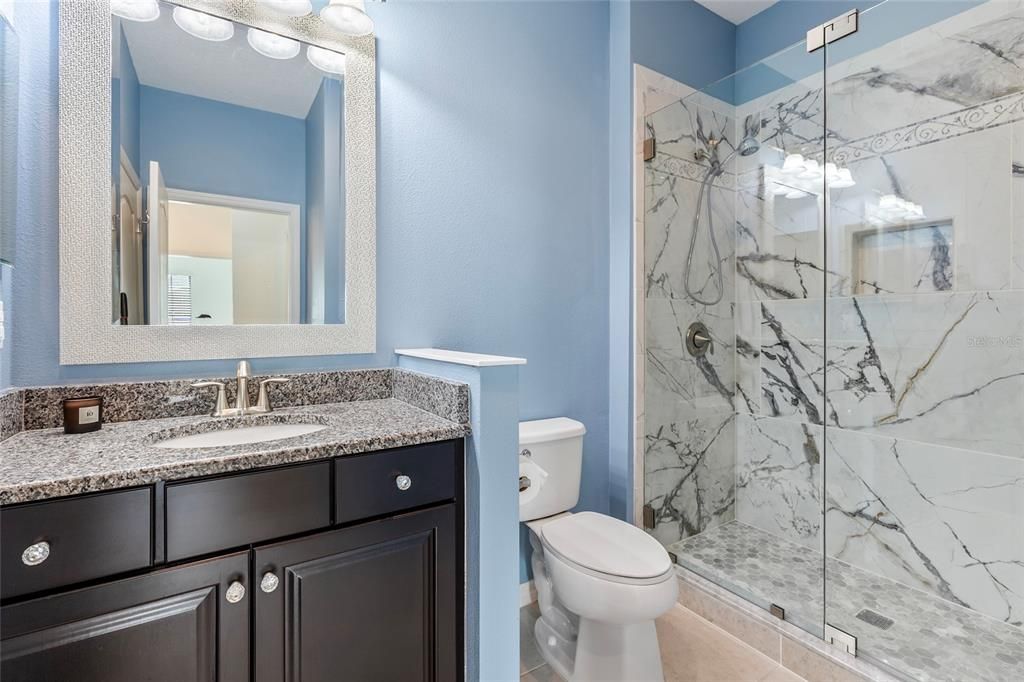 2nd bathroom with upgraded shower tiles and glass door