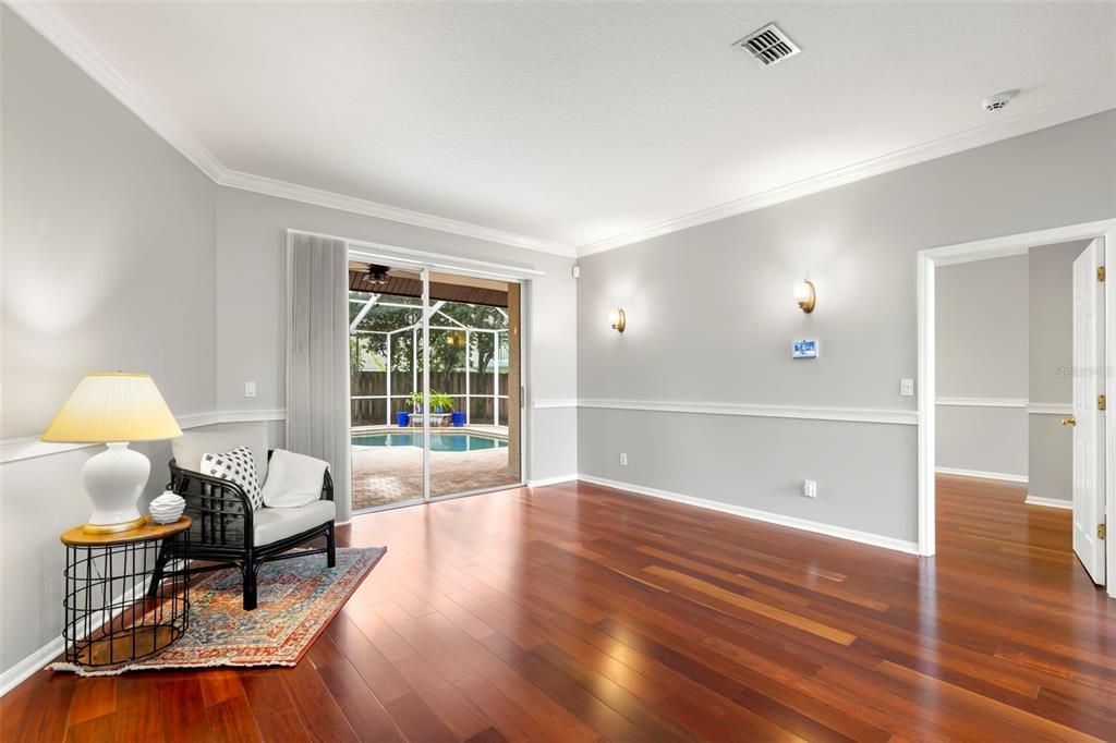 Enter through the front etched glass double doors into the formal living room and dining room with gorgeous cherry wood floors, high ceilings, view of sparkling pool and door to master bedroom.