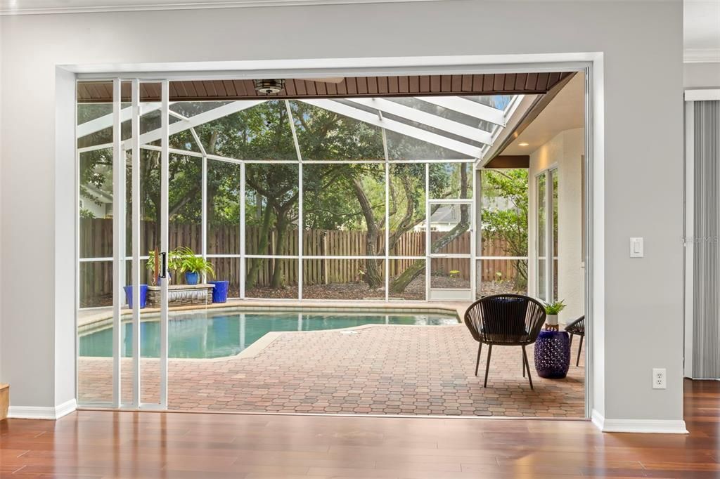 Triple pocket glass sliders open to join the family room with the outdoor pool and patio space.