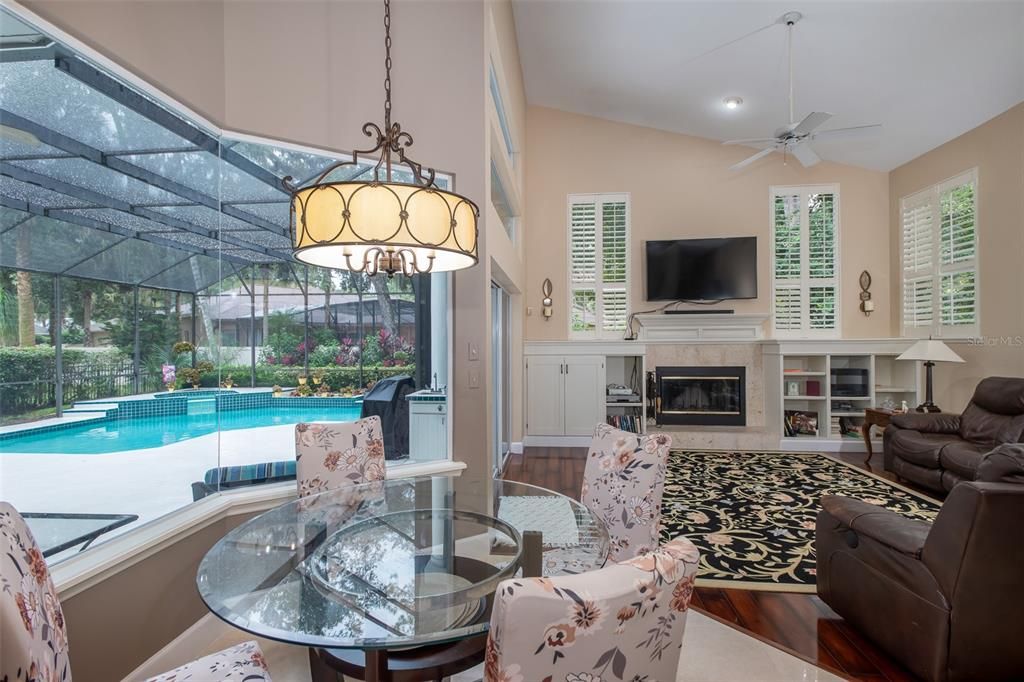 Breakfast nook and family room with large window overlooking pool/patio