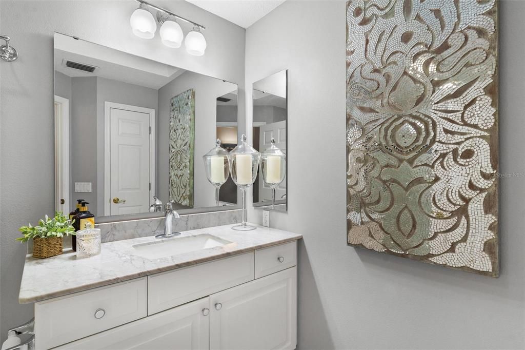 Remodeled Guest Bathroom with a Single Vanity with Marble Countertop