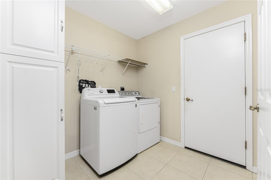 Inside laundry room has extra cabinetry for storage and updated washer & dryer.