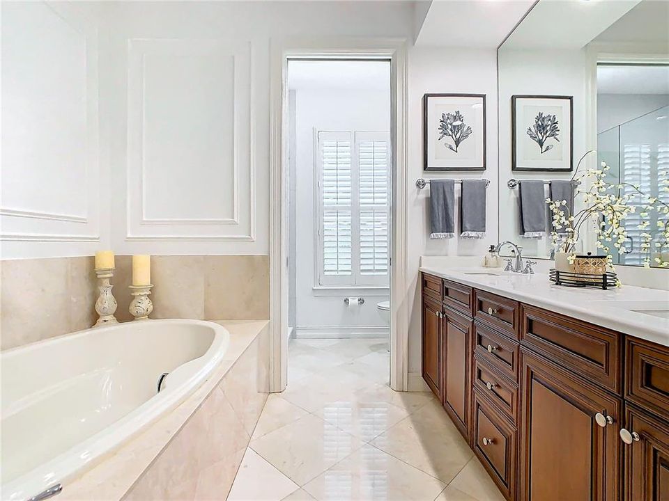 Primary Bathroom with Travertine Flooring and Tub Surround