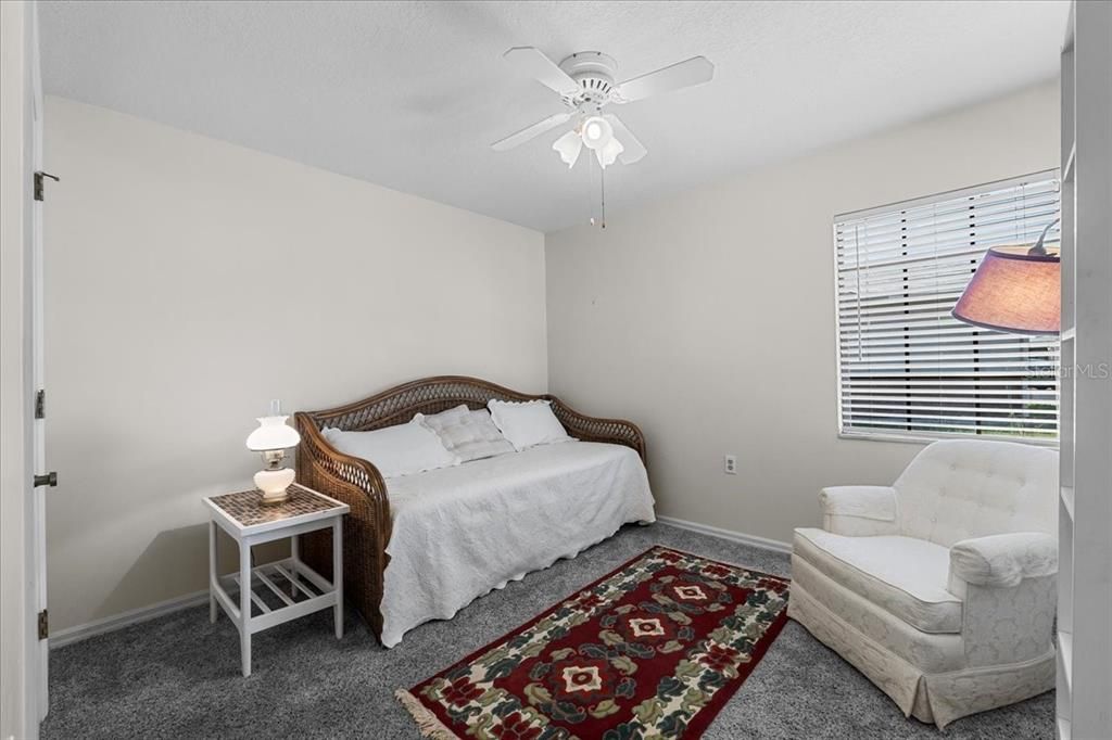 Second bedroom suite with ceiling fan, another walk-in closet, and two windows (one north-facing, one west-facing).