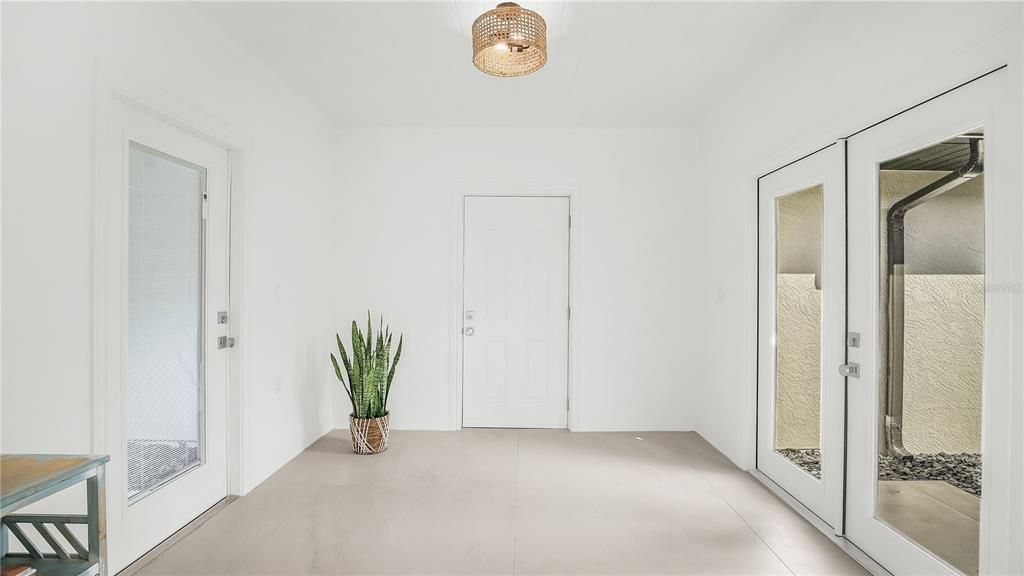 Entry way and flex space with doors leading into the garage and French doors leading to the beautiful backyard oasis.