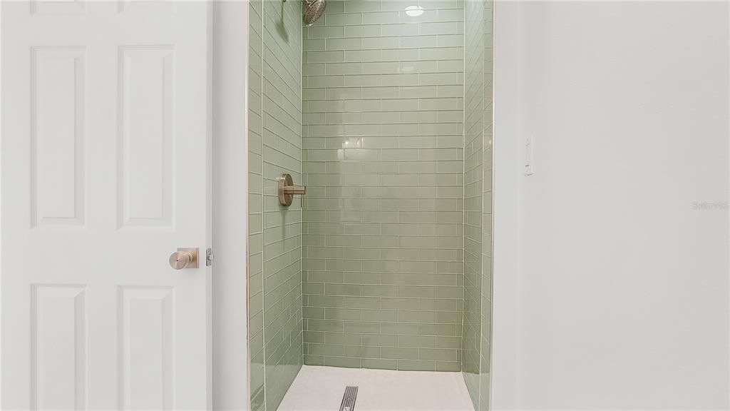 Gorgeous jade glass tile shower.