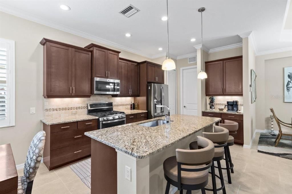 Stunning kitchen featuring granite countertops, stainless steel appliances, wood cabinets, and a dinette.