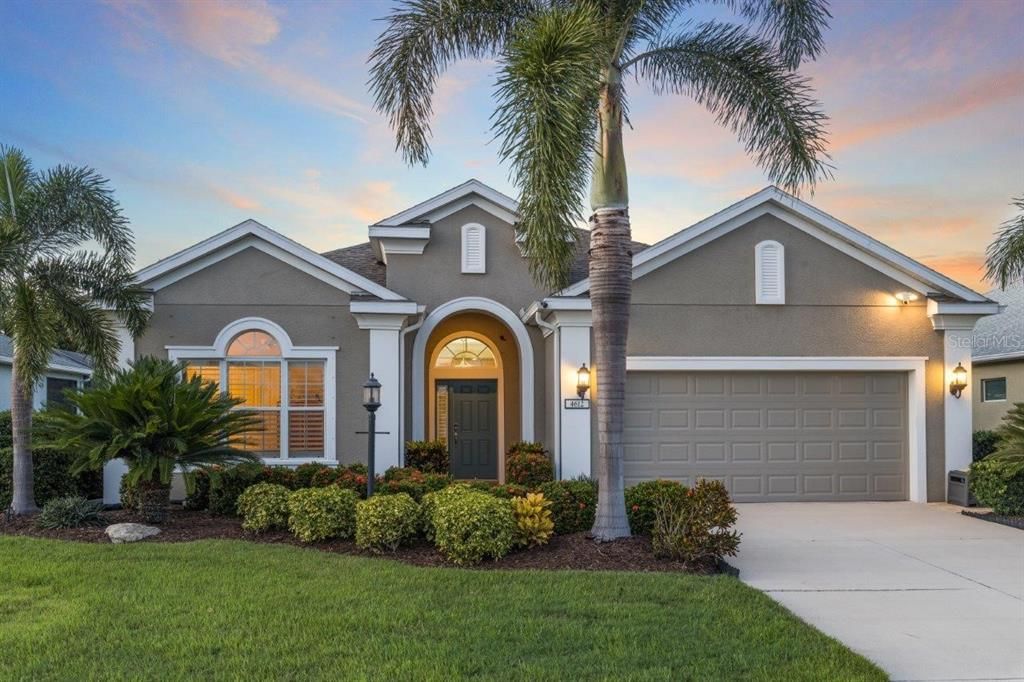 Front Elevation featuring tropical landscaping, custom lighting, and stunning elevation accents.