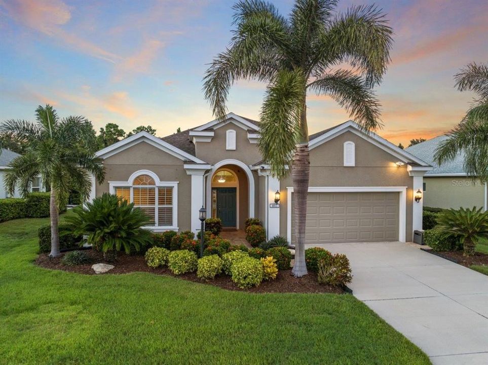 Front Elevation featuring tropical landscaping, custom lighting, and stunning elevation accents.