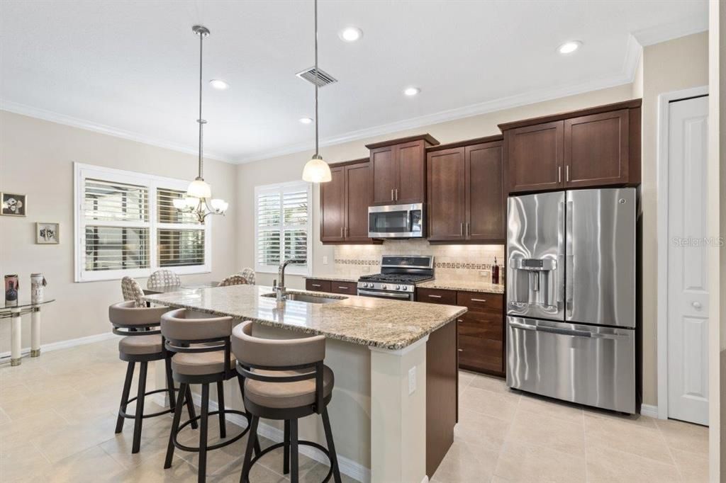 Stunning kitchen featuring granite countertops, stainless steel appliances, wood cabinets, and a dinette.