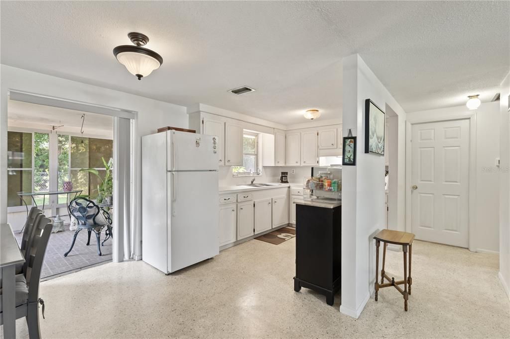 Galley style kitchen featuring ample cabinets, solid surface counter tops, and a garden window.