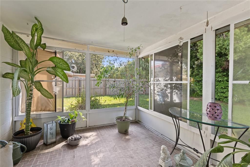 Screened in covered lanai with views of the back yard.