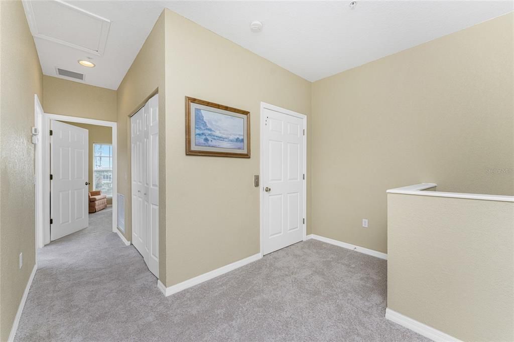 Landing on the third floor show stair well on the right, elevator door and hallway laundry closet.