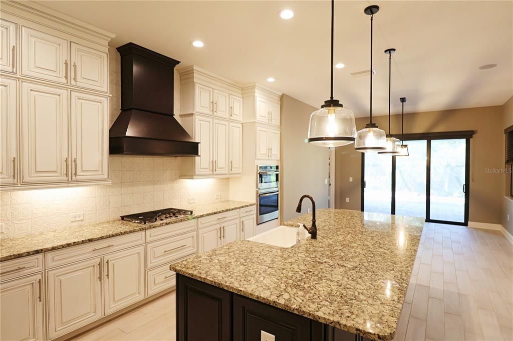 Spacious kitchen with marble tops and gas range.