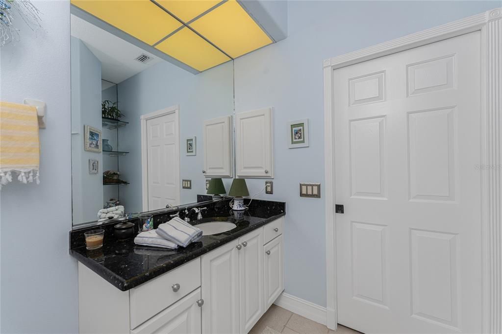 Second bathroom showcases classic black granite with custom built decorative niche