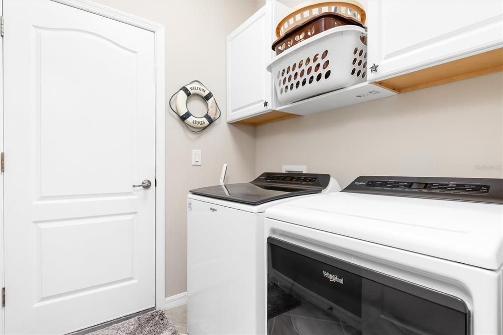 Laundry room with added cabinets and shelving.