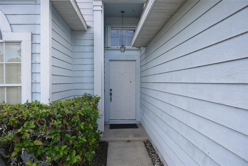 Front covered entry shows transom window for extra lighting into the foyer