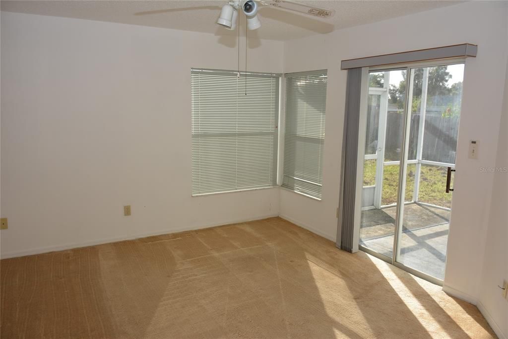 Primary bedroom with sliding door and corner windows brings in plenty of natural light.