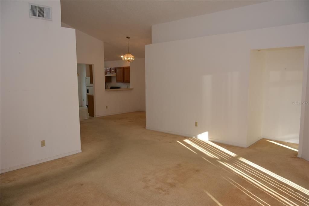 Looking from the Great room into the dining room and kitchen.  Primary bedroom is at the right of the picture.