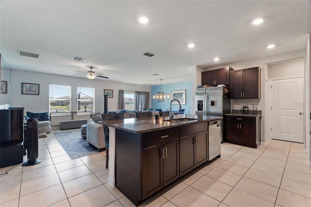 Kitchen with stainless steel appliances, granite countertops, island and bar seating.