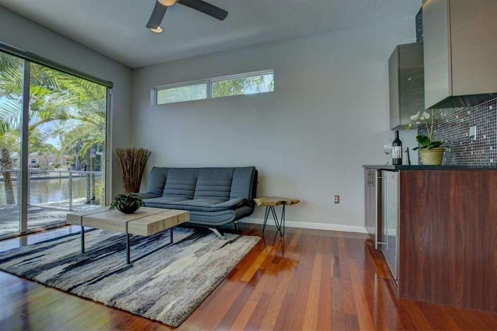 Parlor room boasts walls of glass, views of canal, a wet bar, fridge, separate adjacent bedroom and bath.