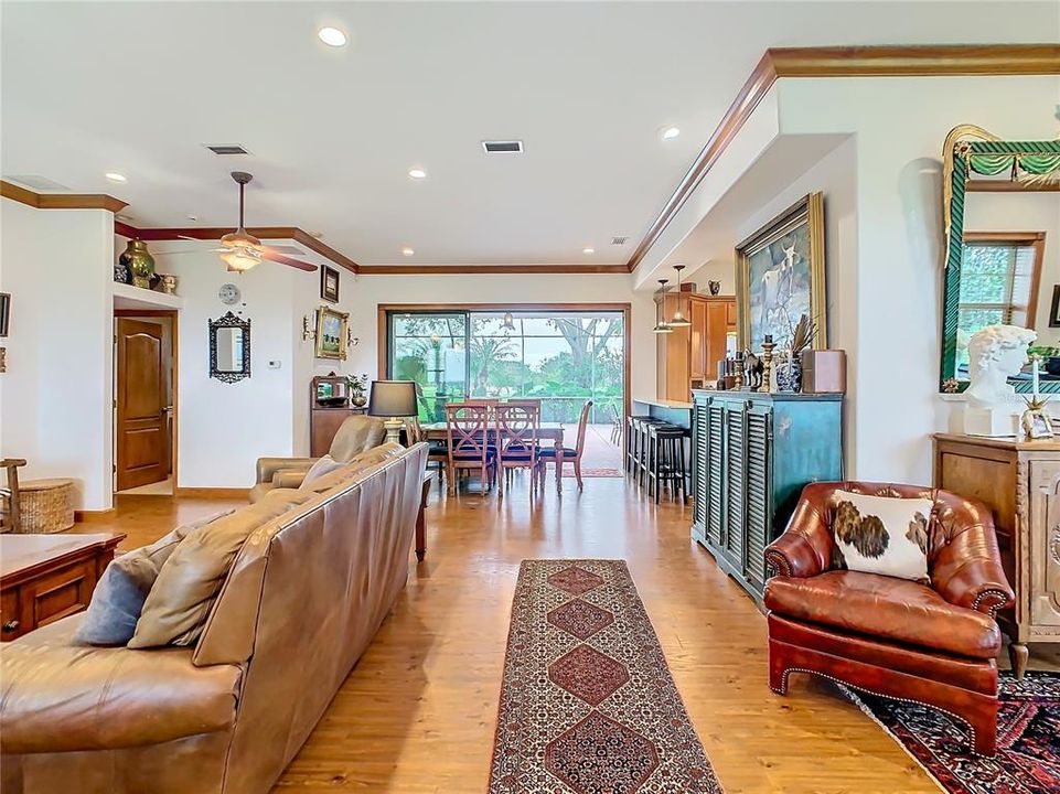 The floor plan is open and spacious with a large living room and a dining room with triple sliding glass doors that open to the screened pool lanai.