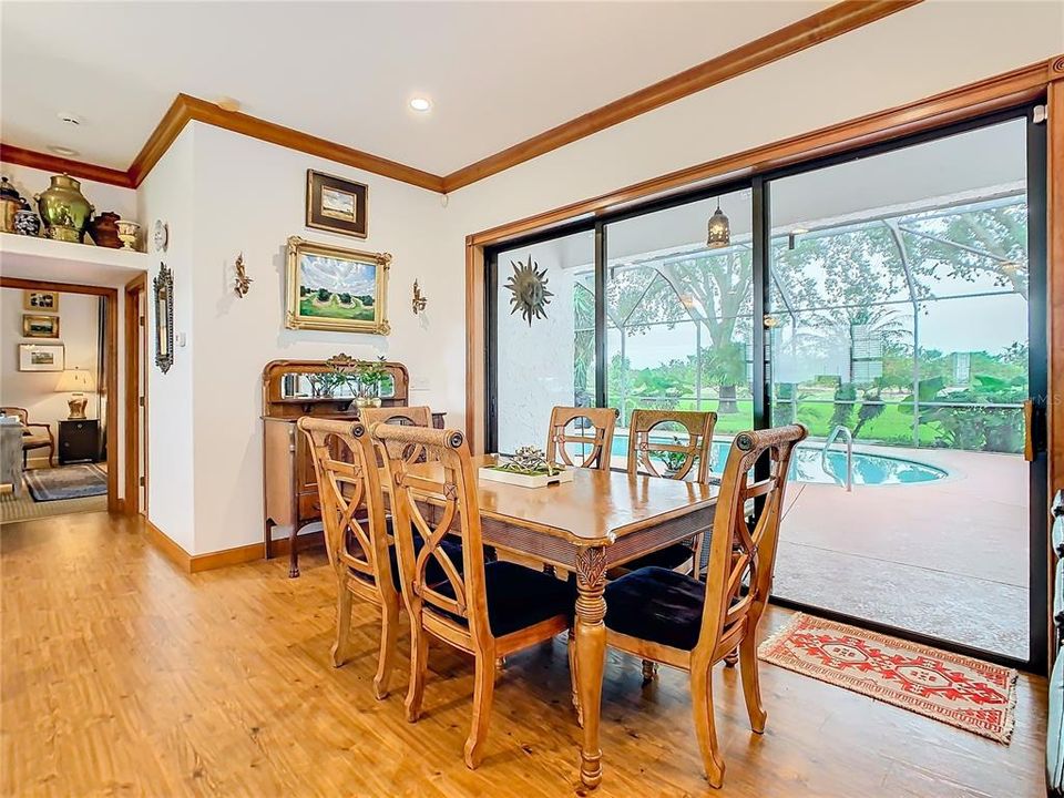 Dining room with triple sliding glass doors that open to the screened pool lanai.