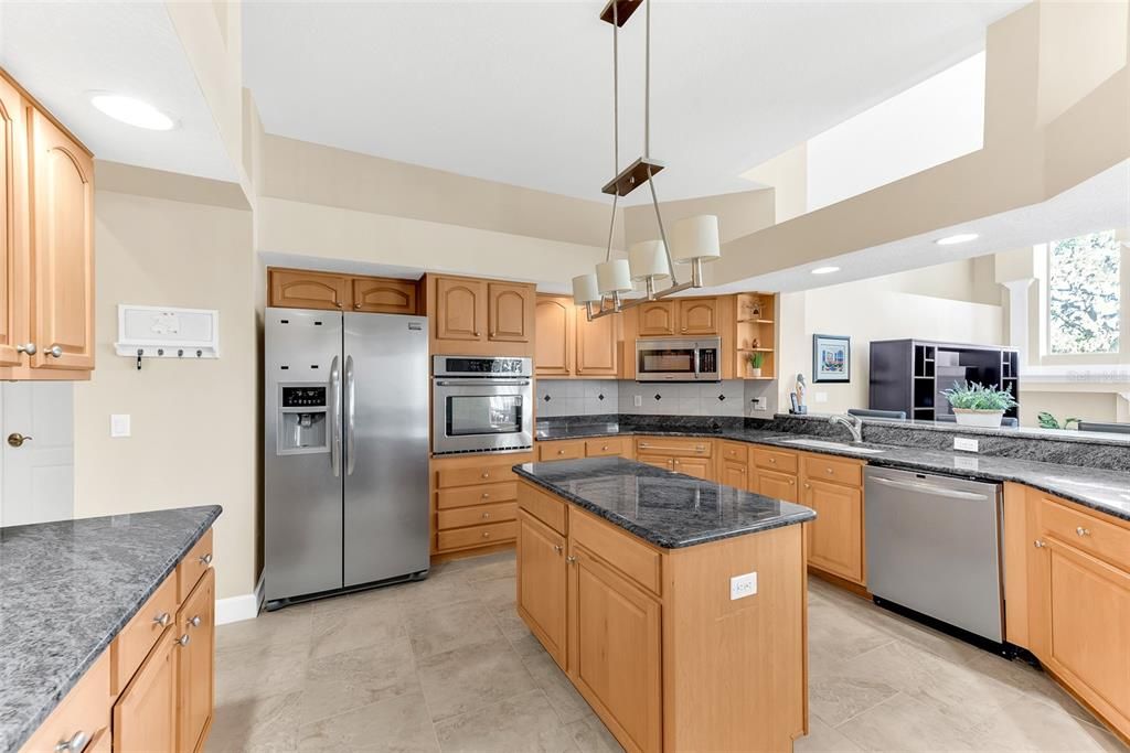 Exquisite granite, wood cabinets, stainless appliances, breakfast bar, and additional kitchen island.