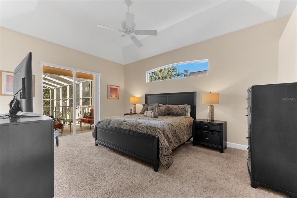 Primary bedroom is huge with sliders out onto a balcony overlooking the screen enclosed pool.