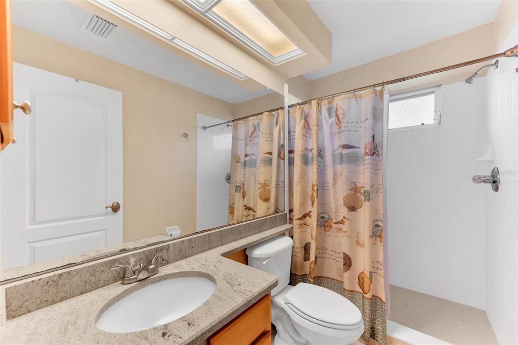 3 piece bathroom downstairs with step in shower and single sink.