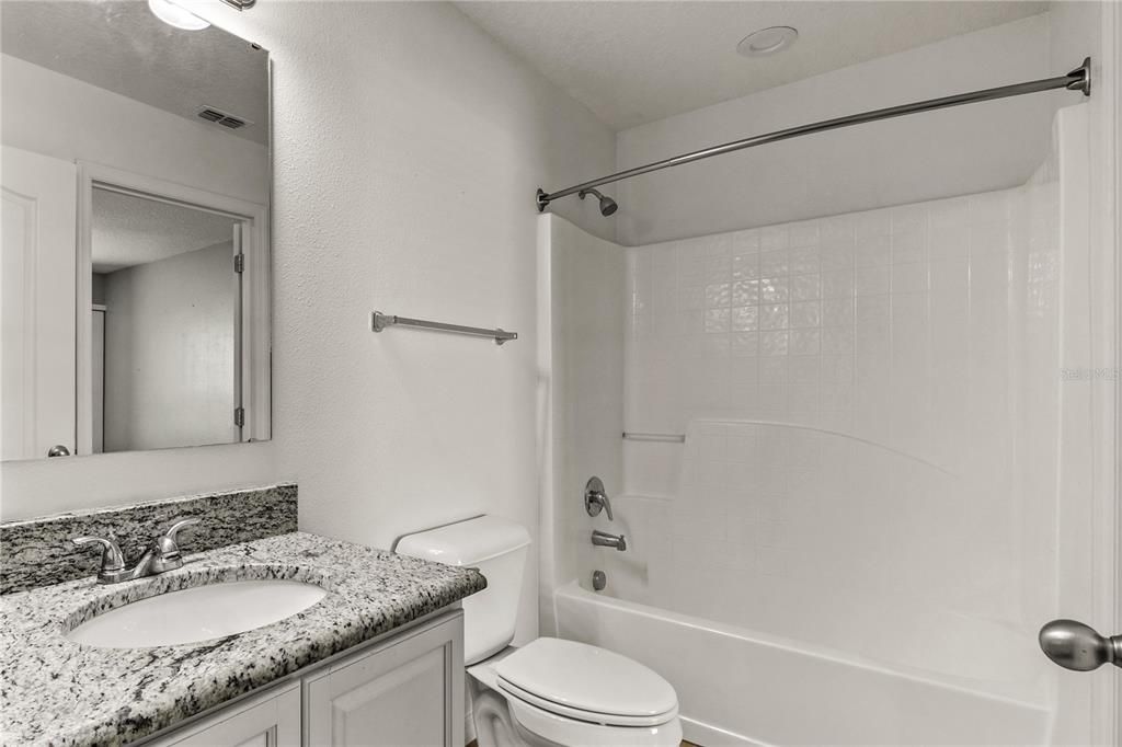 The duel functioning full bath has a tub with shower, a single vanity with granite countertop and ceramic tile floors.