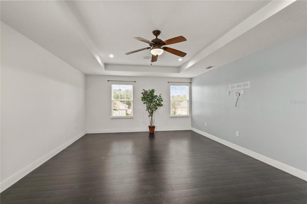 As is the rest of the second story, the Primary suite also has beautiful high end laminate flooring with the 4' baseboards, neutral color tones, a ceiling fan and blinds on all windows. There is also an electric outlet for you to plug in your flst screened TV.