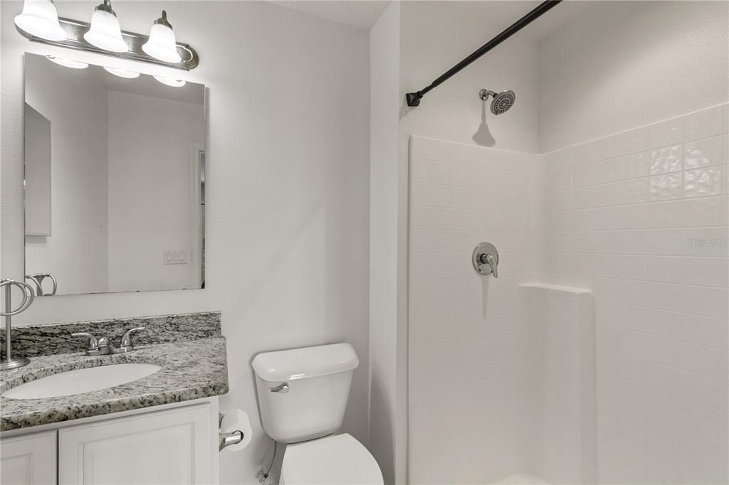 Full Bath #2 has a step-in shower, single vanity with granite countertops and ceramic tile floors.