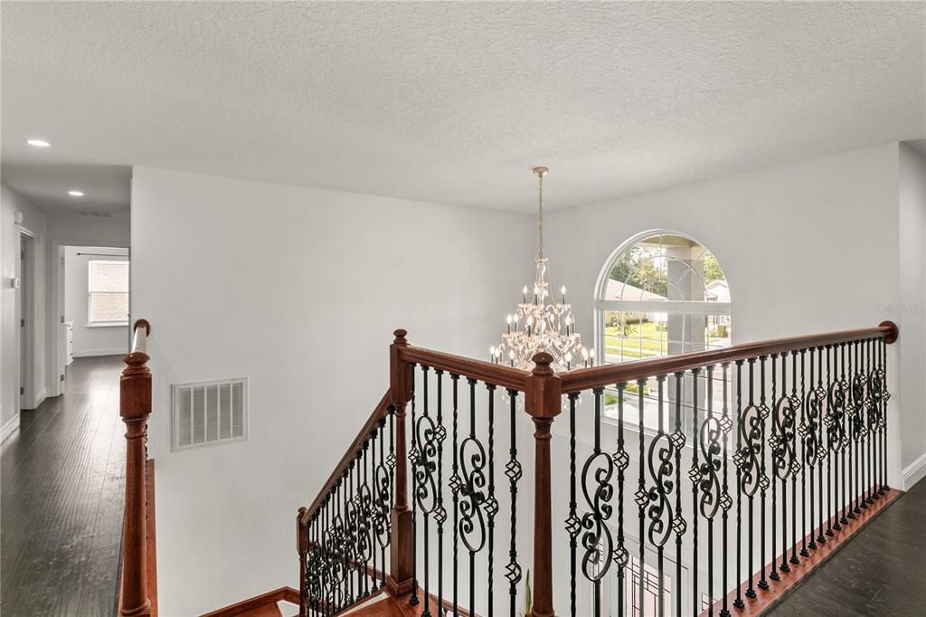 Take a moment and appreciate the craftsmen's detail of this gorgeous rod iron railing and the crystal chandelier  from above.