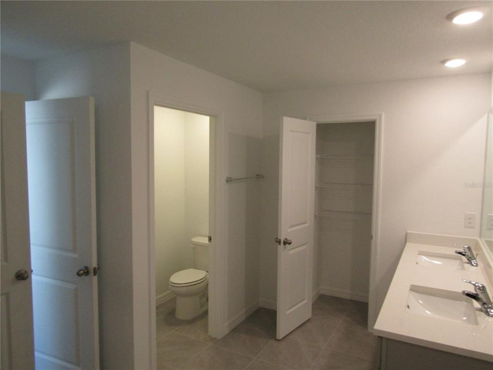 Ensuite bathroom owners suite with separate toilet room and two storage/linen closets