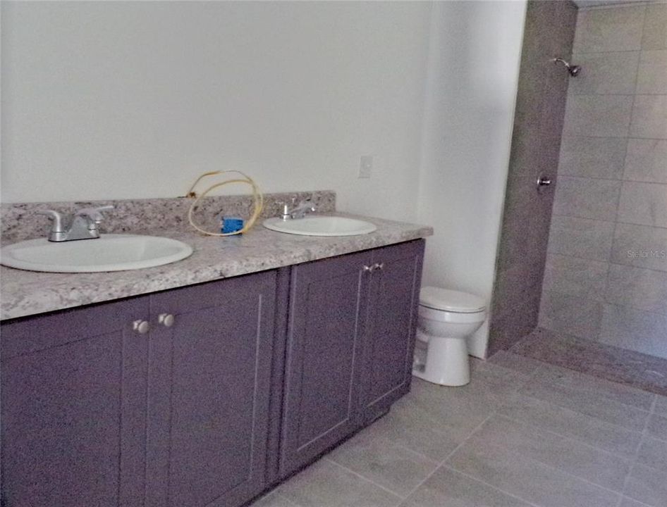 Double Sink, tile floor and shower in Master Suite