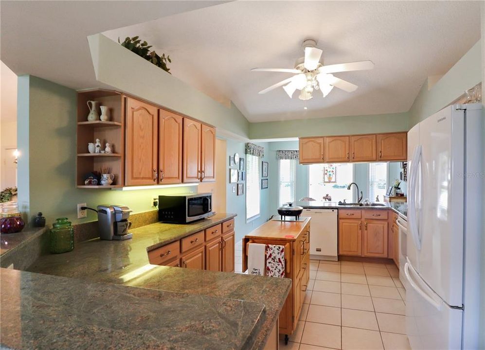 kitchen has granite countertops, wood cabinets and a closet pantry